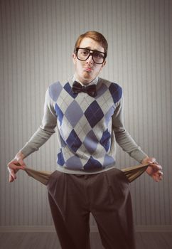 Nerd man stands holding his pockets out showing that he has no money