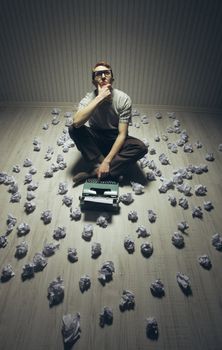 Young writer searching inspiration, with an old typewriter.