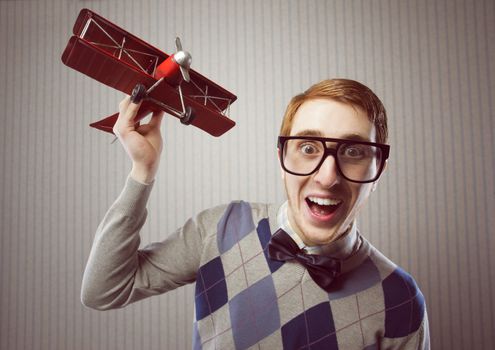 Nerd student playing with a tin airplane