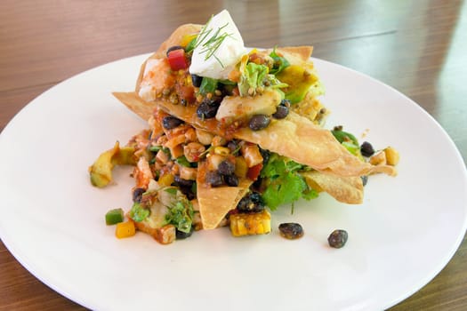 Mexican Chicken Salad with crispy tortilla avocado black beans spiced corn sour cream and salsa