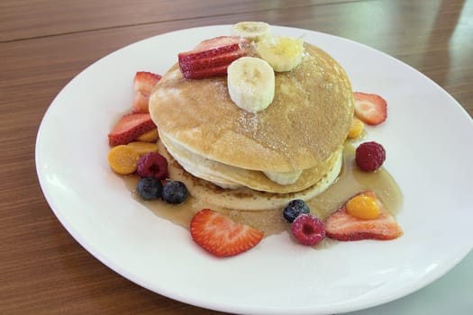 Hotcakes with Blueberries Strawberries Raspberries Banana and Honeycomb