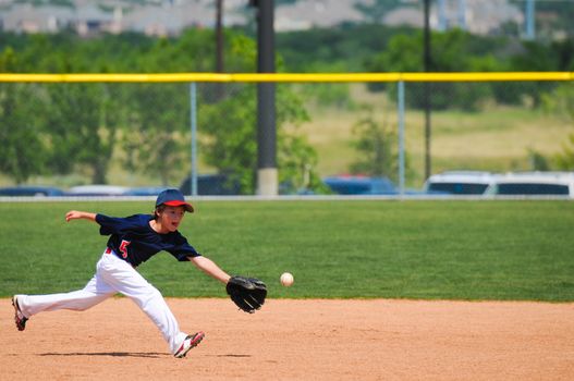 Little league baseball boy reach out to catch ball