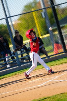Young baseball batter swinging the bat.