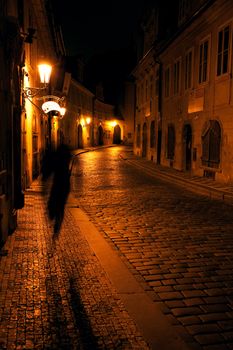 a beautiful night view of the street and the shadow of a man in Prague