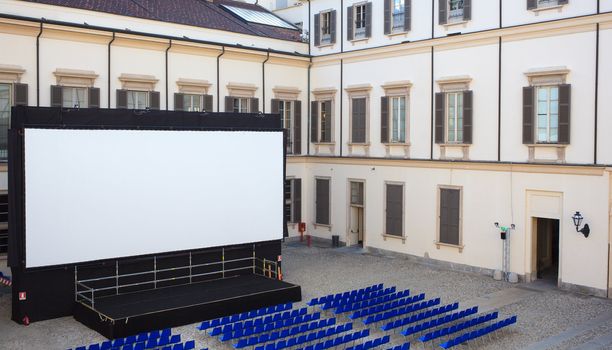 View of screen and Empty blue chairs for outdoor cinema