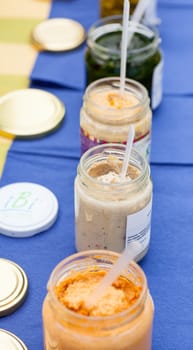 A lot of soup jars on a blue table