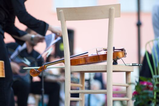 Violin on a wooden chair before the concert