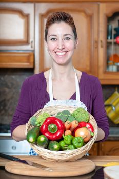 beautiful housewife with basket of vegetables in the kitchen