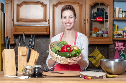 beautiful housewife with basket of vegetables in the kitchen