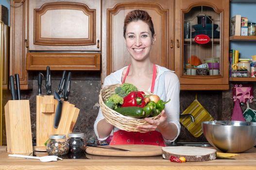 beautiful housewife with basket of vegetables in the kitchen