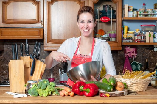 beautiful housewife cooking vegetables in the kitchen