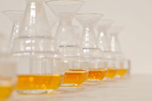 Glass bottles in row with yellow liquid