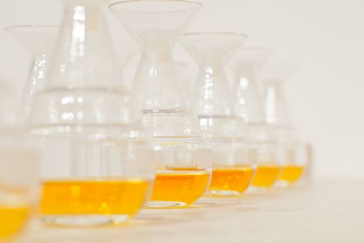 Glass bottles in row with yellow liquid