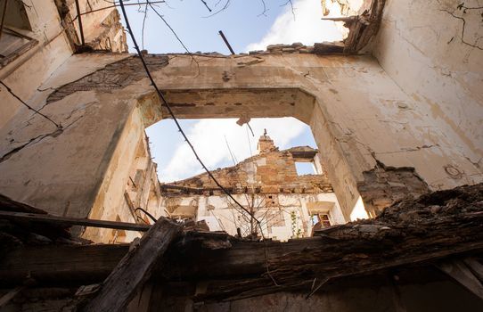 View of demolished house with rubble and cracked wall