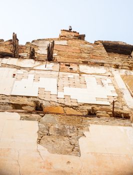 View of demolished house with rubble and cracked wall