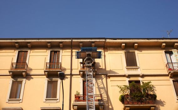 Extendable lift in action on a balcony, Milan