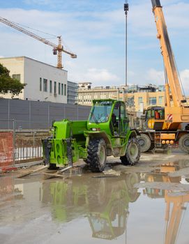 Green excavator in a construction site