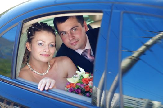 portrait of bride and groom in the car