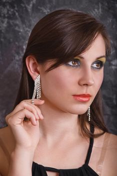 Portrait of a beautiful brunette in luxury earrings.