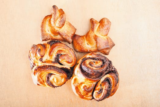 Freshly homemade sweet rolls on a wooden table.