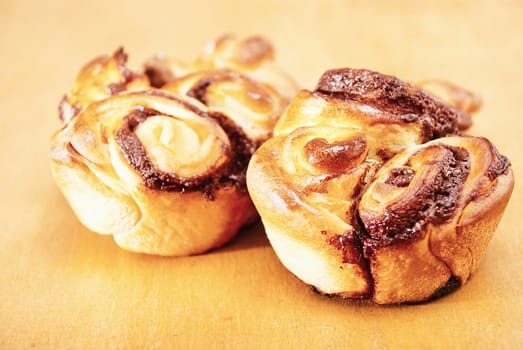 Closeup freshly homemade sweet rolls on a wooden table.
