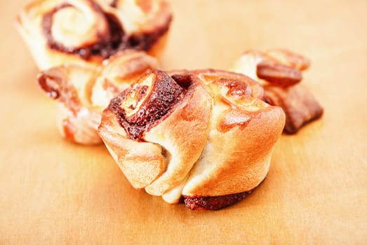 Closeup freshly homemade sweet rolls on a wooden table.