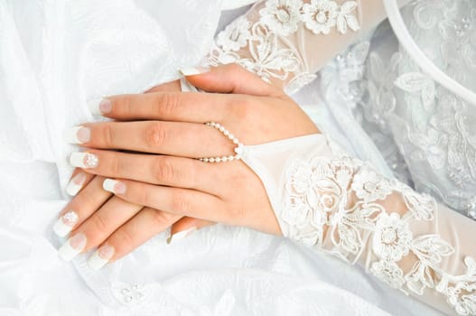bride holding her hands on a white wedding dress. Hand on a hand