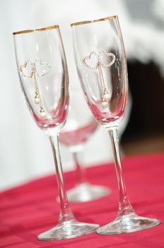 two transparent wedding wine glasses with a heart ornament. symbol of love