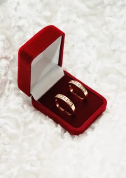 two gold diamond rings in open box. Love symbol