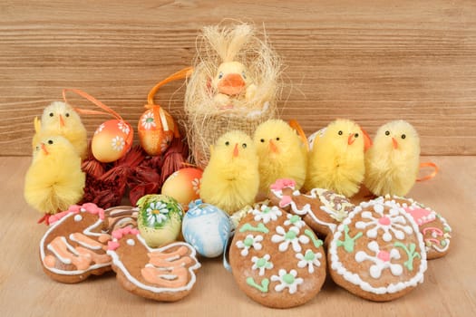 easter decoration, ginger bread, chicken and painted eggs wooden background