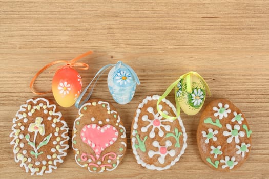 Easter ginger breads and painted egg on wooden background