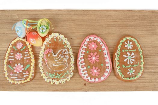 Easter ginger breads and painted egg on wooden background