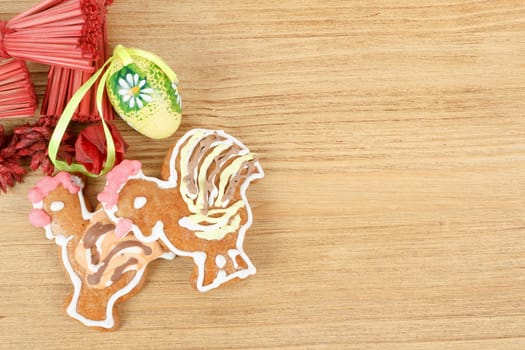 Easter ginger breads and painted egg on wooden background