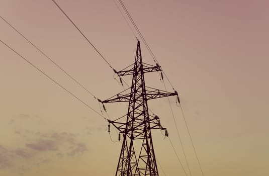 silhouette of high metal electricity tower with wire. Sunset time