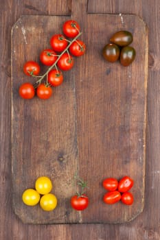 Set of different varieties of cherry tomatoes on a dark wooden background