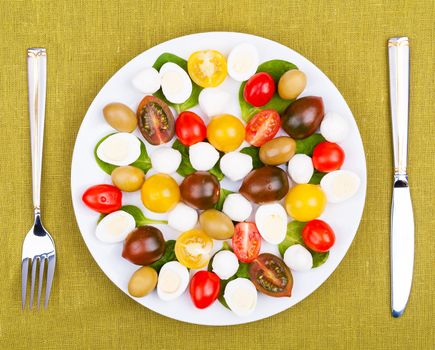 White plate with salad on the background of a linen tablecloth