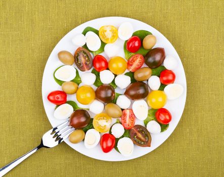 White plate with salad on the background of a linen tablecloth