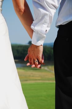 holding hands with wedding rings together 