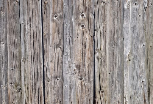Fragment of weathered rough uncolored wooden boards background
