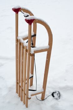 Wooden sled for a kid in fresh snow