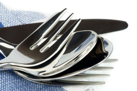 Silverware with Table Knife, Spoon, Fork, Dessert Spoon and Dessert Fork on Blue Napkin closeup