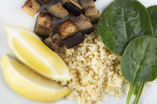 Fresh vegetable ingredients with spinach, eggplant/aubergine, lemon and bulgar