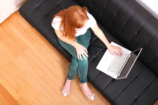 A young, brazilian woman surfing on the Internet with a Laptop.  