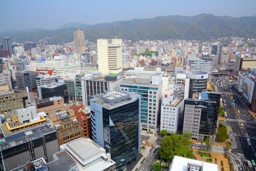 Kobe, Japan - city in the region of Kansai in Hyogo prefecture. Aerial view with skyscrapers and mountains.