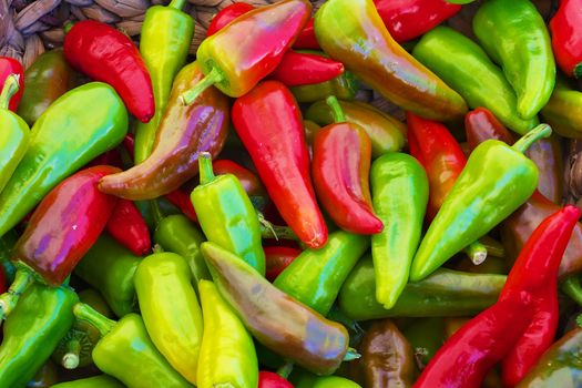 red green yellow purple hot Peppers at the farmers market with sharp focus on center vegetables