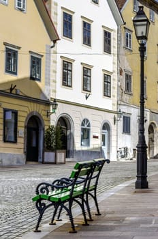 Two small benches in an old Ljubljana alley.