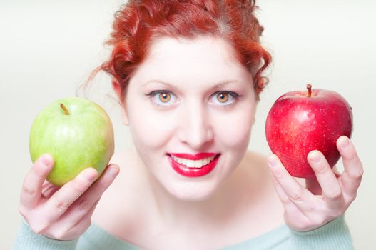 beautiful red hair and lips girl with green and red apple on white background