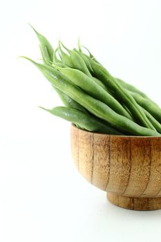 fresh beans fruit into wooden bowl on white background .
