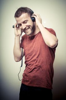 vintage portrait of fashion smiling guy with headphones on gray background