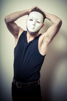 vintage portrait of fashion guy with white mask on gray background